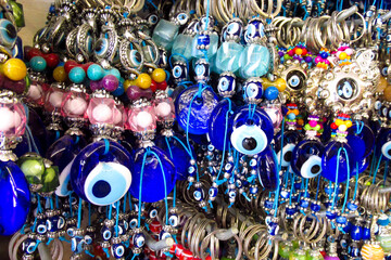 Fototapeta premium Traditional Turkish Nazar amulets used for protection. Nazar Boncugu Glass ornaments with circular patterns in blue, white, and black, displayed in rows. Close-up of blue evil eye protective amulet