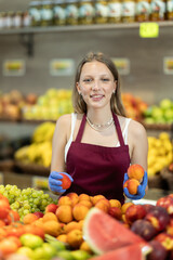 Shop seller put goods on display case. Girl creates stock of peach in display case, forms showcase....