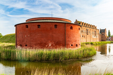 Impressive round tower of historic Malmohus Castle surrounded by water