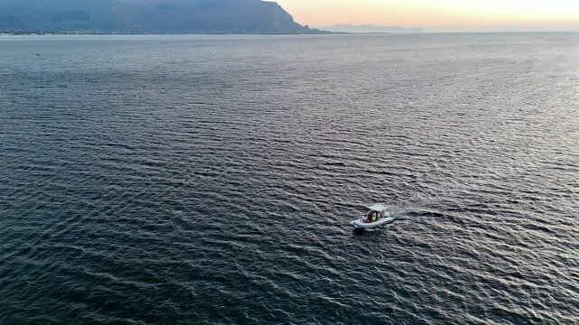 giro su gommone con vista estiva al tramonto dell'isolotto dall'alto con drone 360 mentre genera onde