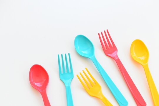 colorful spoon and fork isolated on white background, plastic cutlery for picnic