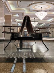 in stylish space elegant curved seating arrangement made of wood. sparkling chandeliers hang above,...