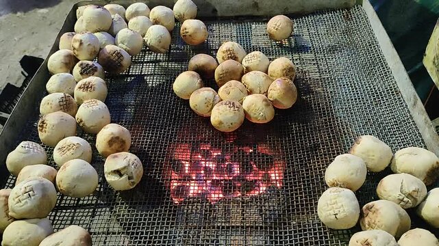 4k video clip of making litti chokha snacks baking on hot fire oven in a street side in India