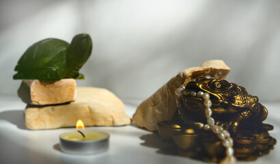 Jade turtle on stone podium, mascot symbolizing prosperity, success and longevity. The Money Frog, Three-Legged Toad or Chan Chu, charm. Wealth, prosperity. Attract financial opportunities. Candleligh