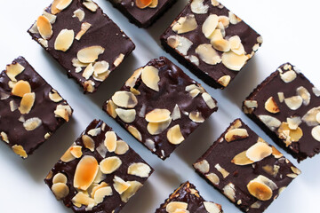 Set Chocolate Brownies pieces with topping almond slice on white background. Top view