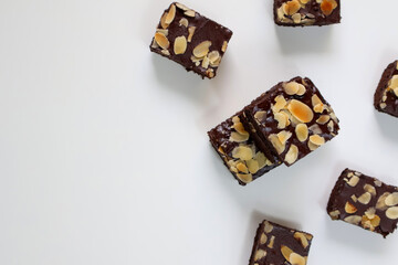 Homemade Chocolate Brownies cake with topping almond slice on white background. Top view with copy space
