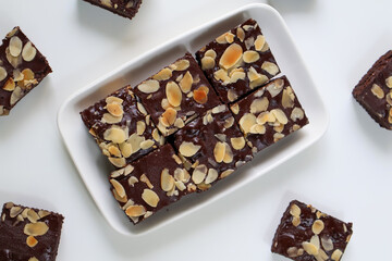 Homemade Chocolate Brownies with topping almond slice on plate. on white background. Top view....