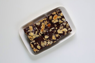 Chocolate Brownies with topping almond slice on plate. on white background. Top view