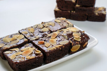 Chocolate Dessert, Homemade bakery, Chocolate Brownies with topping almond slice on plate. on white...