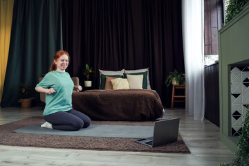 Young woman practicing yoga indoors in a cozy and stylish bedroom environment