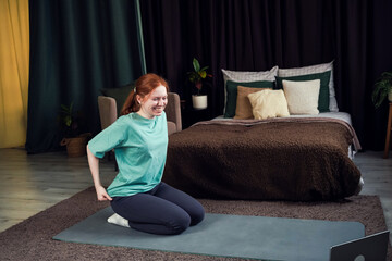 Young woman practices yoga on mat in cozy bedroom during morning routine