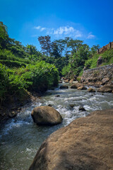 Portrait image of river flow with several beautiful stones