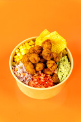 Vegetable and protein poke bowl on orange background. Complete and detail of the dish.
