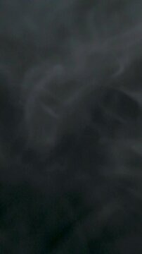 Slow motion of white smoke, fog, mist, vapor on a black background.