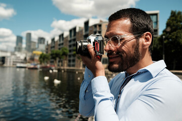 Photographer taking pictures in london docklands with vintage camera