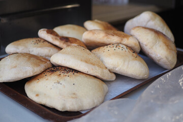 Freshly baked pita bread on a tray in a bakery