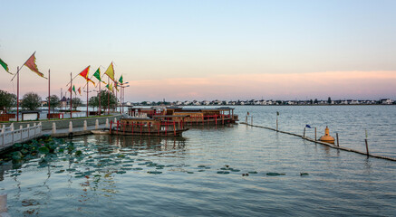 Tranquil Sunset Over Water with Vibrant Flags and Calm Reflections