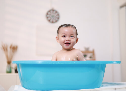Baby's morning routine, cleaning baby and infant in the bath, hygiene, health or wellness with mother at home