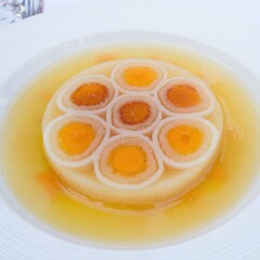 Macro shot of an artistic dish styled to resemble bacteria or virus cells, plated with fine-dining elegance on a minimalist table in soft lighting.