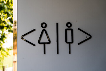 Restroom door with male and female symbols on wall. Toilet sign