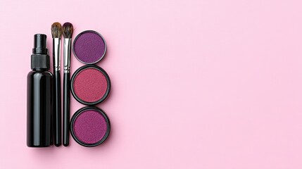 Flat lay of makeup products on a pink surface.