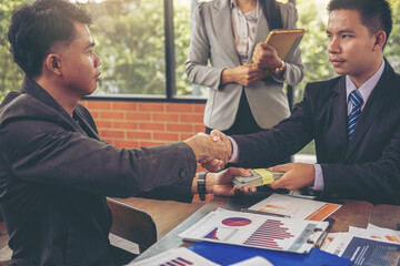 Businessman handshake at business meeting after negotiations with business partners and making investment. Selected focus