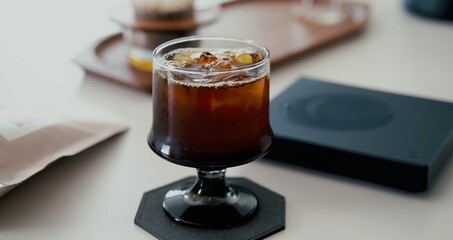 A glass of whiskey with ice on the table