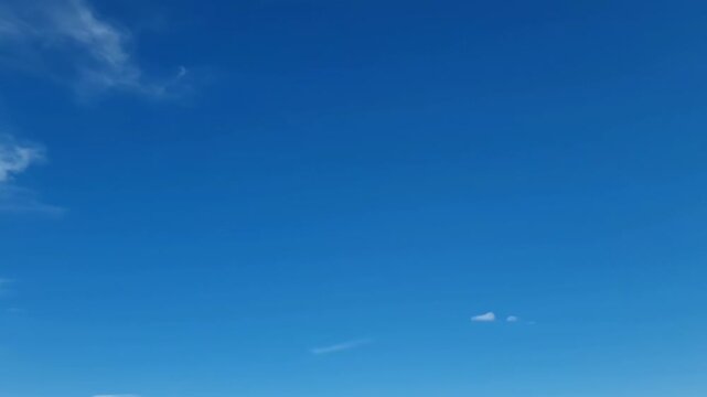 A vivid blue sky sparsely dotted with a few scattered clouds