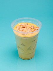 Mango charlotte in plastic cup on light blue background