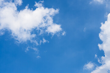 Bright blue sky filled with fluffy white clouds on a clear summer day. Nature Background.