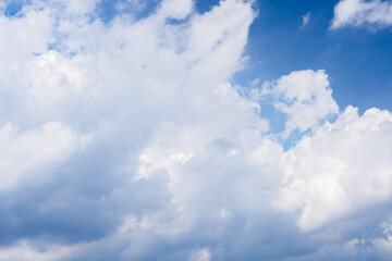 Blue sky filled with white fluffy clouds on a bright sunny day in nature