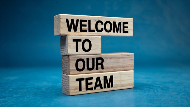 Wooden blocks stacked to spell out welcome to our team against a vibrant blue background symbolizing new beginnings and team integration