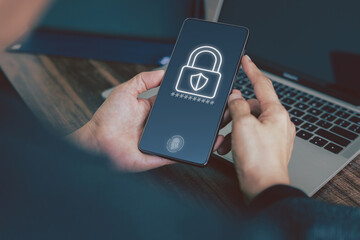 Concepts of data protection, authentication, privacy. A person is holding a smartphone on screen show lock icon, a line of asterisks representing a password, and a fingerprint icon on the screen.