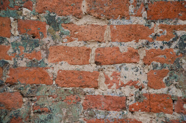 Background of an old brick wall with traces of gray cement