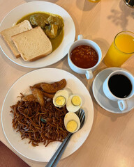 Breakfast set with noodles, bread, curry, eggs.
