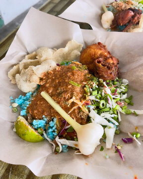 Colourful nasi kerabu with crispy chicken.