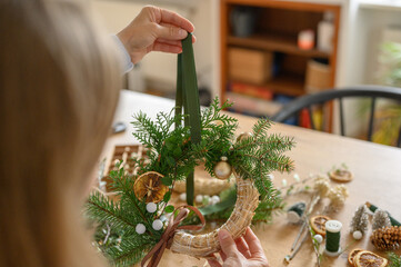 woman making christmas wreath with natural materials