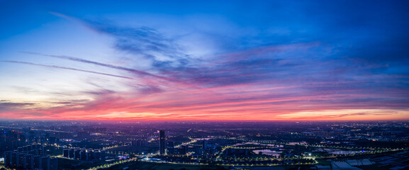Panoramic view of city skyline with spectacular colorful sky clouds at dusk