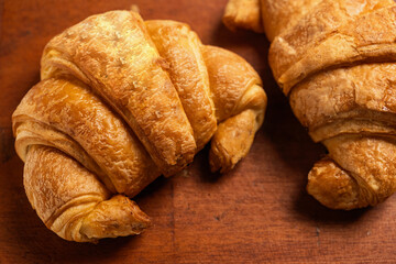 Freshly baked croissants on a wooden background. Top view