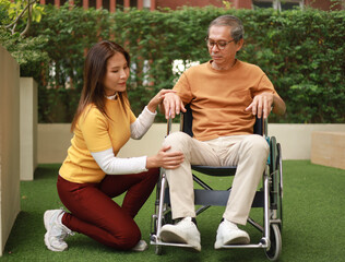 Obraz premium Help support retirement health care. A man is being cared for privately at home by an Asian woman who has Alzheimer's and is being closely monitored.