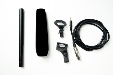Studio microphone for podcasting or streaming with audio cable and a set of mic stands on a white background. Top view