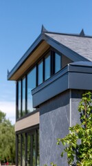 Modern architectural design featuring synthetic slate roof and contemporary gutter system.