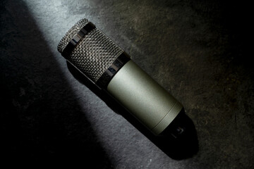 Studio microphone for podcasting or streaming with a black background. Top view