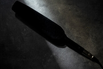 Studio microphone for podcasting or streaming with a black background. Top view