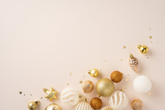 Festive ornaments in gold and white scattered on a neutral background with stars and sparkles