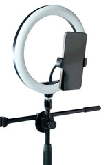 Round LED ring light with a cellphone on a phone holder isolated over a white background. Vlogging or live streaming equipment. Mockup or Copy space