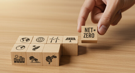 Hand placing net zero cube alongside environmental icons on wooden blocks