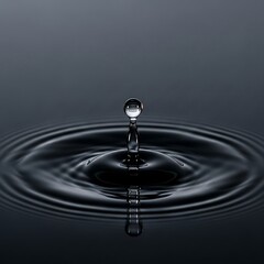 Translucent Water Drop Creating Ripples on Dark Surface with Reflection