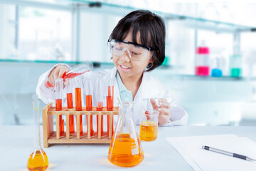 Young Asian Girl Enthusiastically Mixing Chemicals in a Science Lab