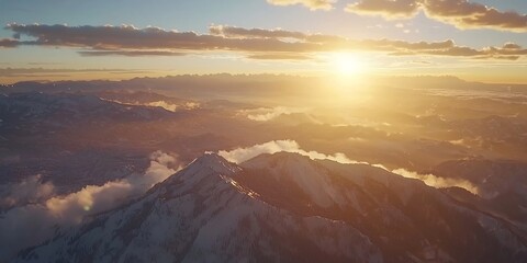 Obraz premium Majestic snow-covered mountain peaks bathed in the warm glow of the rising sun